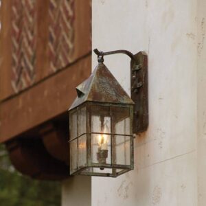Lancaster 7 inch wall lantern with scrolled hook and Window Pane overlay illuminated against a light exterior wall